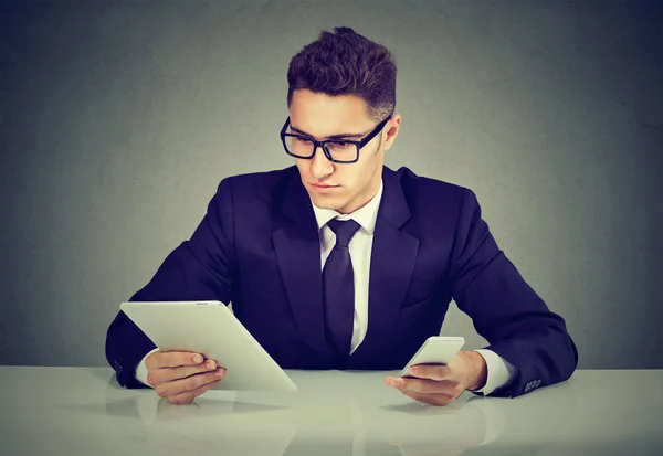 Hombre de negocios guapo con gadgets en la mesa — Foto de Stock