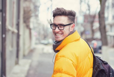 Şehir arka plan üzerinde mutlu yakışıklı öğrenci