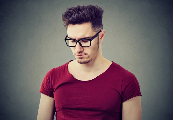 Занятый молодой человек в очках на сером — стоковое фото