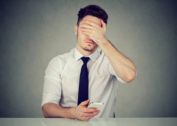 Homme avec téléphone couvrant le visage dans le désespoir — Photo