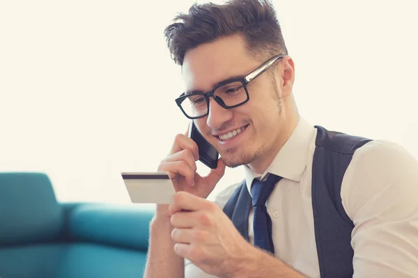 Hombre usando servicio telefónico y tarjeta de crédito — Foto de Stock