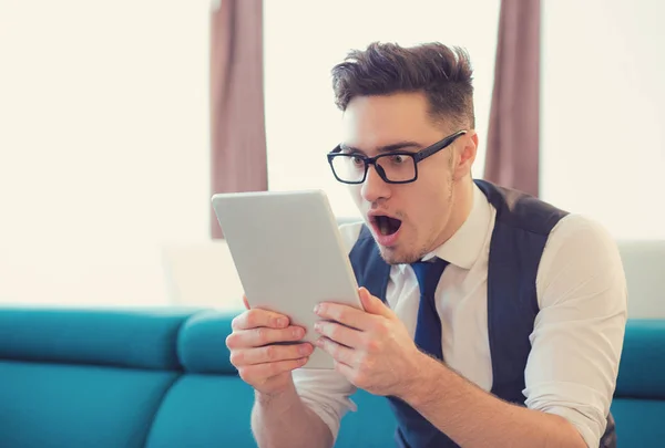 Aufgeregter überraschter Mann schaut Tablet — Stockfoto