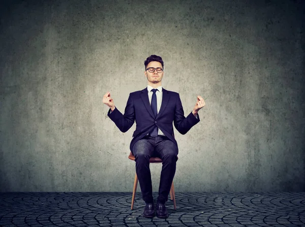 Young business man meditating on chair Stock Image