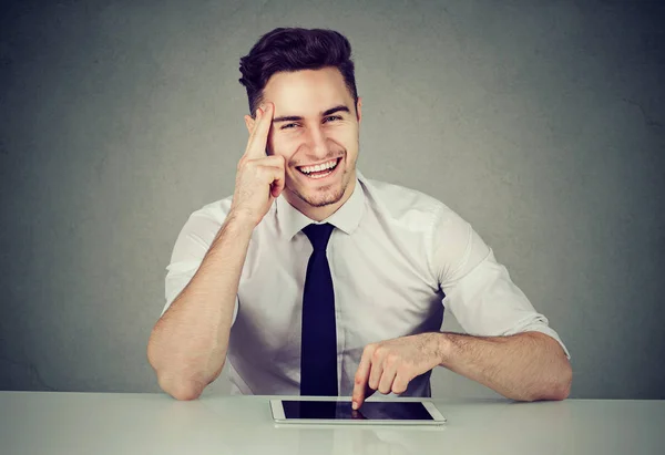 Hombre de negocios exitoso con la tableta sentada en el escritorio sonriendo mirando a la cámara —  Fotos de Stock