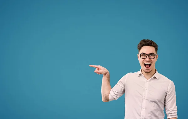 Unga hipster mannen i glasögon pekar gärna bort — Stockfoto