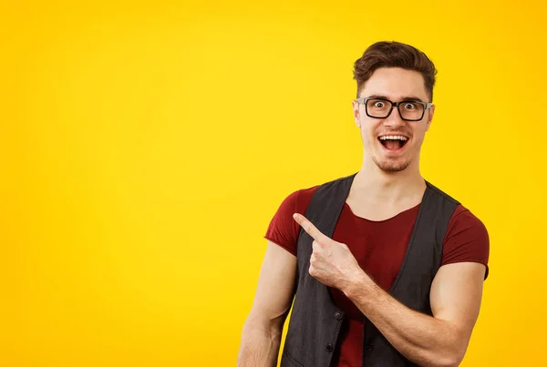 Jeune homme hipster élégant dans des lunettes pointant heureusement loin — Photo