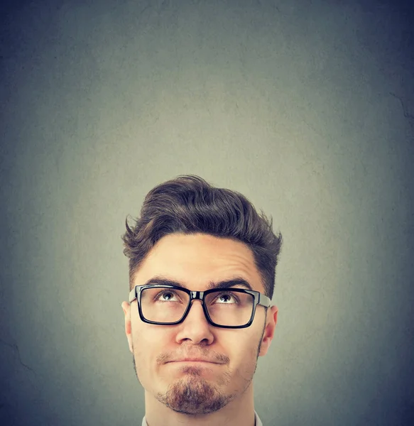 Hombre serio con gafas negras mirando hacia arriba pensando — Foto de Stock