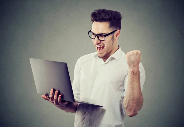 Aufgeregter Mann mit Laptop feiert Erfolg — Stockfoto