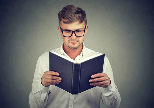 Умный человек в очках, читающий книгу — стоковое фото
