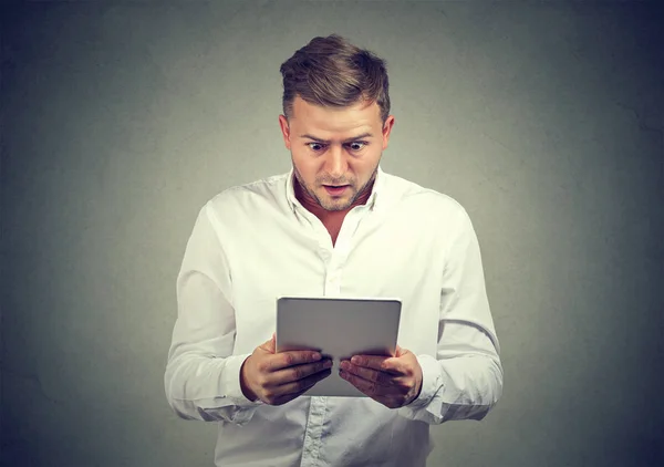 Schockierter Mann erkundet Nachrichten in Tablet — Stockfoto