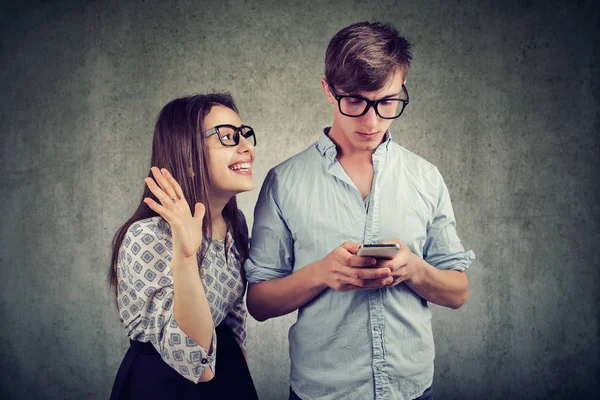 Kobieta stara się zwrócić uwagę przystojny mężczyzna, ignorując jej za pomocą smartfona — Zdjęcie stockowe