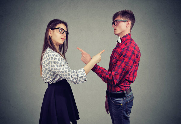 Раздражённые мужчина и женщина сталкиваются с проблемами в отношениях, указывая пальцем друг на друга, обвиняя в ошибках
