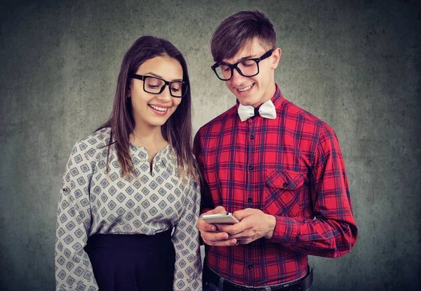 Feliz chico hipster eccentic sosteniendo el teléfono inteligente, mostrando a su novia fotos divertidas — Foto de Stock