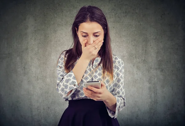 Chockad tjej läsande smartphone — Stockfoto