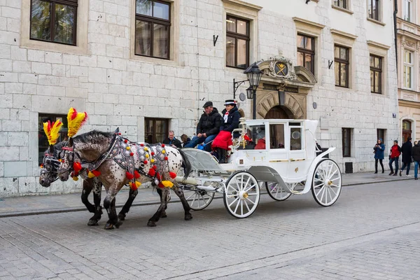 Krakow, Polonya - 21 Nisan 2017: Atlar atlı arabaları Krakow eski şehirde. Krakow ikinci büyük ve Polonya'nın en eski şehirlerinden biridir.
