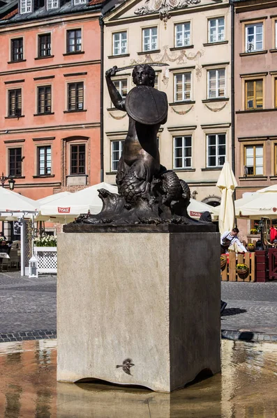 Varsovia, Polonia - 23 de abril de 2017: Estatua de la Sirena (Syrenka - símbolo de Varsovia) en la Plaza del Mercado de la Ciudad Vieja contra viviendas y restaurantes . —  Fotos de Stock