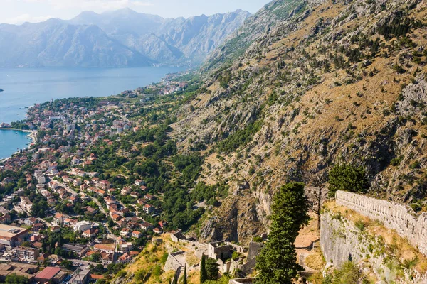 Olhando sobre a Baía de Kotor em Montenegro com vista para montanhas, barcos e casas antigas com telhados de azulejos vermelhos — Fotografia de Stock