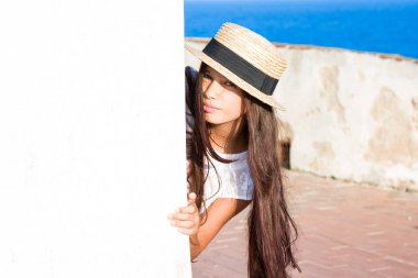 Hasır Şapkalı kız dışarı duvarın arkasından iletiye göz atar