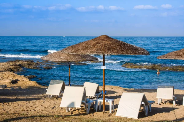 Praia do Mediterrâneo com espreguiçadeiras vazias pela manhã, Paphos, Chipre — Fotografia de Stock
