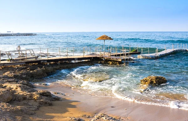 Fırtına ve deniz arka planda iskelede Sunumbrella — Stok fotoğraf