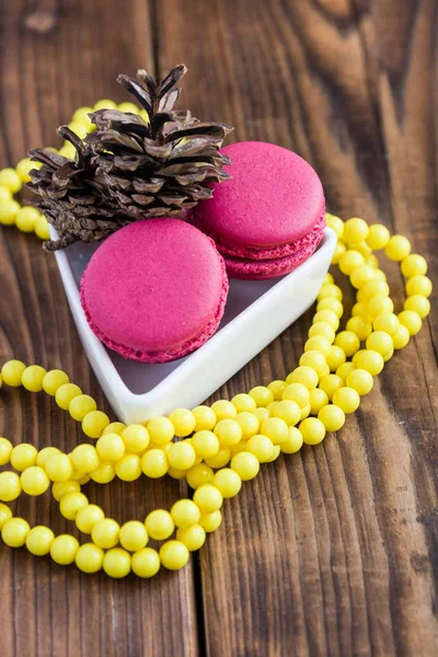 Pink macaroons with christmas decorations on woooden background — Stock Photo, Image