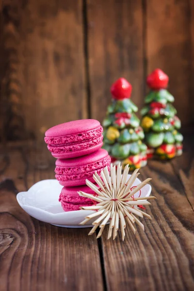 Pink macaroons with christmas decorations on woooden background — Stock Photo, Image