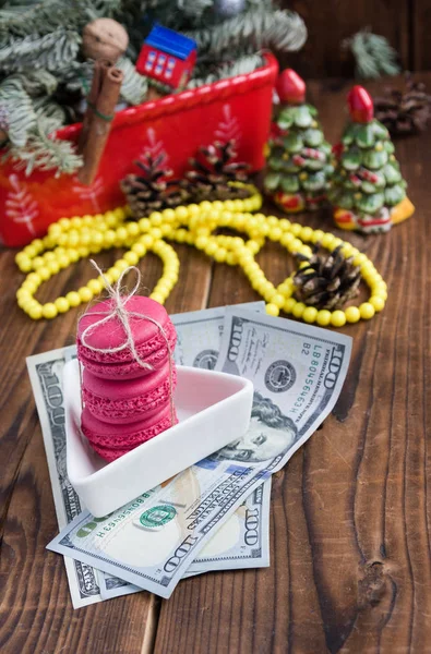 Розовые макароны и двадцать долларов с рождественскими украшениями на фоне дерева — стоковое фото