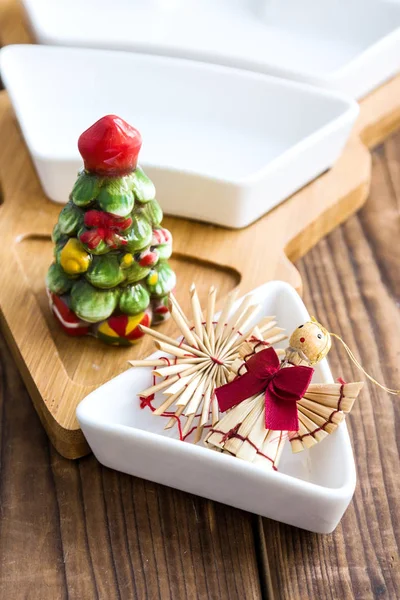 Christmas straw toys and bowl with salt shaker on wood — Stock Photo, Image