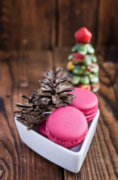 Pink macaroons with christmas decorations on wooden background — Stock Photo, Image