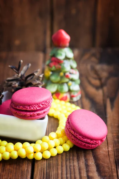 Macaroni rosa con decorazioni natalizie su sfondo di legno — Foto Stock