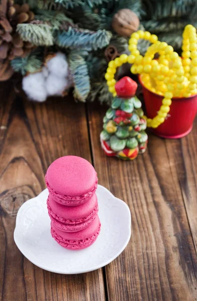 Macaroons rosa com decorações de Natal em fundo de madeira — Fotografia de Stock