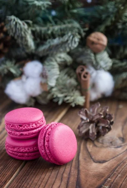 Macaroons rosa com decorações de Natal em fundo de madeira — Fotografia de Stock