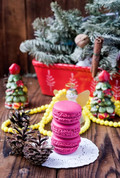 Różowy makaroniki z ozdobami świątecznymi na tle woooden — Zdjęcie stockowe