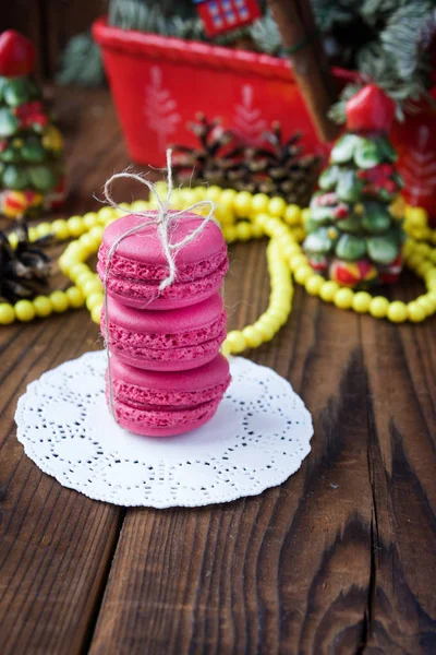 Macarrones rosados con decoraciones navideñas sobre fondo de madera —  Fotos de Stock