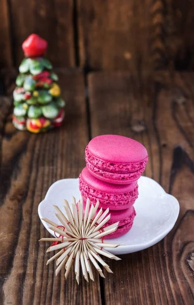 Macaroons rosa com decorações de Natal em fundo de madeira — Fotografia de Stock