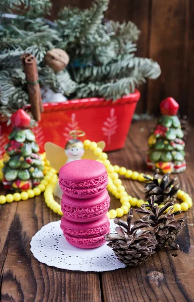 Rózsaszín macaroons, karácsonyi díszek, a fából készült háttér — Stock Fotó