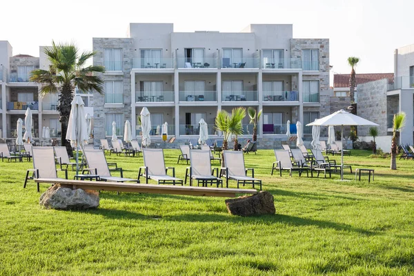 Paphos, Chypre - 20 juillet 2017 : Palm beach avec chaises longues vides contre Amphora Hotel & Suitel. Situé sur l'emplacement idyllique en bord de mer de l'ancienne cave SODAP — Photo