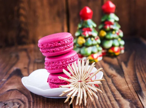 Macarrones rosados con decoraciones navideñas sobre fondo de madera —  Fotos de Stock