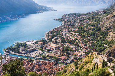 Karadağ Kotor Körfezi üzerinde dağ manzaralı seyir, tekneler ve eski evler kırmızı kiremit çatılar