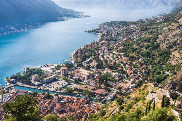 Olhando sobre a Baía de Kotor em Montenegro com vista para montanhas, barcos e casas antigas com telhados de azulejos vermelhos — Fotografia de Stock