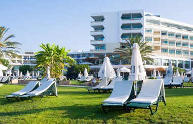 Paphos, Kıbrıs - 20 Temmuz 2017: Palm beach Constantinou Bros Athena Beach Hotel karşı boş şezlong ile. Otel tam olarak 10/11 kışında yenilenmiştir