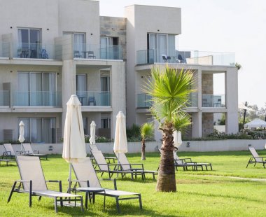 Paphos, Kıbrıs - 20 Temmuz 2017: Palm beach Constantinou Bros Athena Beach Hotel karşı boş şezlong ile. Otel tam olarak 10/11 kışında yenilenmiştir