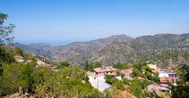 Mountain Village Pedoulas, Cyprus. View over roofs of houses, mountains and Big church of Holy Cross. Village is one of most picturesque villages of Troodos mountain range clipart