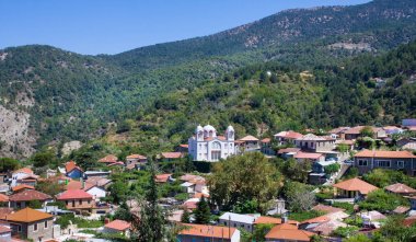 Dağ köyü Pedoulas, Kıbrıs. Evler, dağlar ve büyük kilise Holy Cross çatılarda görüntüleyin. Troodos dağ aralığının en güzel köylerinden köyüdür