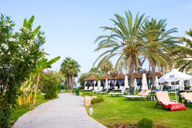 Paphos, Kıbrıs - 20 Temmuz 2017: Palm beach Constantinou Bros Athena Beach Hotel karşı boş şezlong ile. Otel tam olarak 10/11 kışında yenilenmiştir