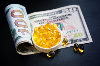 Balık yağı ve siyah arka plan üzerine dolar kapsül