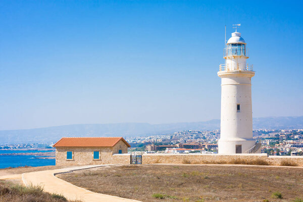 Old white lighthouse near the ancient ruins in Paphos Archaeological Park, Cyprus