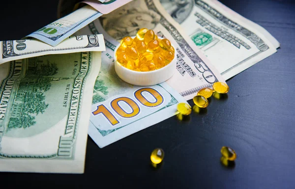 Balık yağı ve siyah arka plan üzerine dolar kapsül