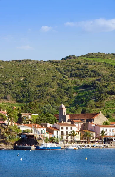 COLLIOURE, FRANÇA - JULHO 5, 2016: Hotéis de praia na aldeia de Collioure com um moinho de vento no topo da colina, Roussillon, Vermilion coast, Pyrenees Orientales, França — Fotografia de Stock