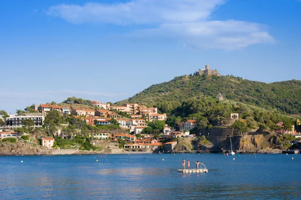 Beach hotels in Collioure village with a windmill at the top of the hill, Roussillon, Vermilion coast, Pyrenees Orientales, France — Stock Photo, Image